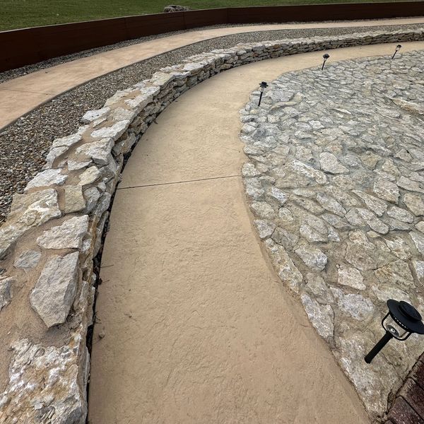 Curved stone walkway with lamps.
