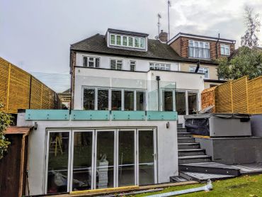 Modern two-story house with large windows and garden view.