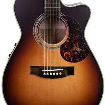 Close-up of a sunburst acoustic guitar with six strings and a tortoiseshell pickguard.