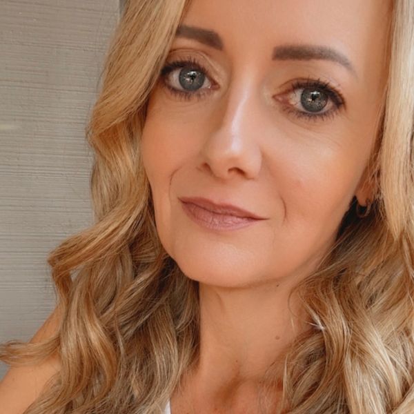 Close-up portrait of a woman with wavy blonde hair.