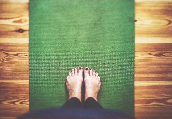 Client standing on pilates mat