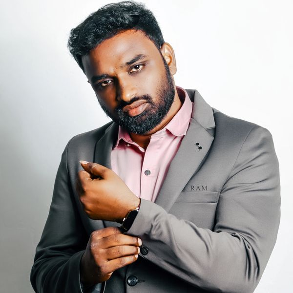 Man adjusting his sleeve wearing a suit and watch.