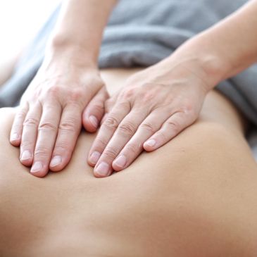 Two hands massaging a back