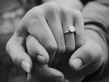 Close-up of hands with an engagement ring, symbolizing love and commitment.