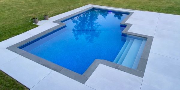 Piscine creusée en béton au design architectural avec lignes géométriques distinctives et marches