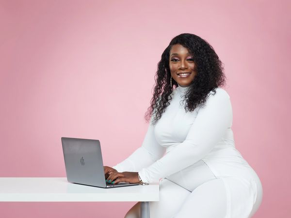 woman CEO at desk with hands on MacBook keyboard
