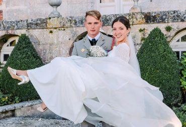 Un couple de mariés heureux, le marié porte la mariée dans ses bras.