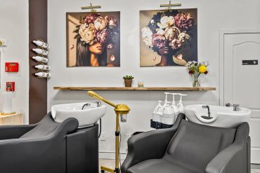 Modern hair salon interior with floral artwork.
