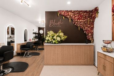 Elegant salon reception area with floral décor and wooden accents.