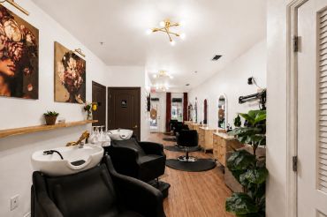 Modern hair salon interior with wash stations and styling chairs.