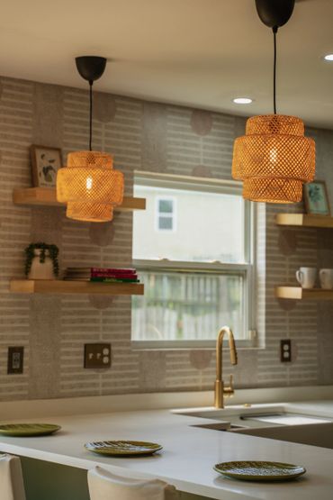 Warm kitchen with woven pendant lights and open shelving.