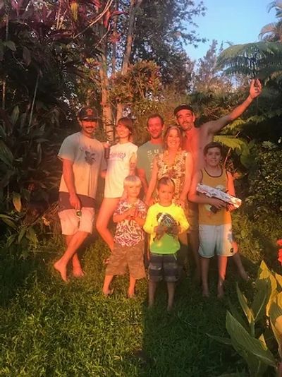 A group of people along with some children standing in a jungle