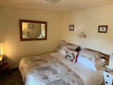 Cozy bedroom with a large bed and a mirror on the wall.