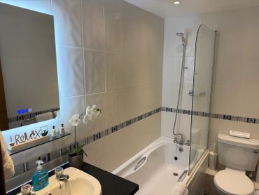 Clean and modern bathroom with bath and shower.