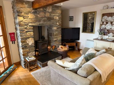 Cozy living room with stone fireplace and beige sofa.