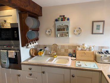 Cozy kitchen countertop with sink and organized utensils.