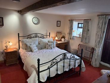 Cozy bedroom with a black iron bedframe and floral bedding.