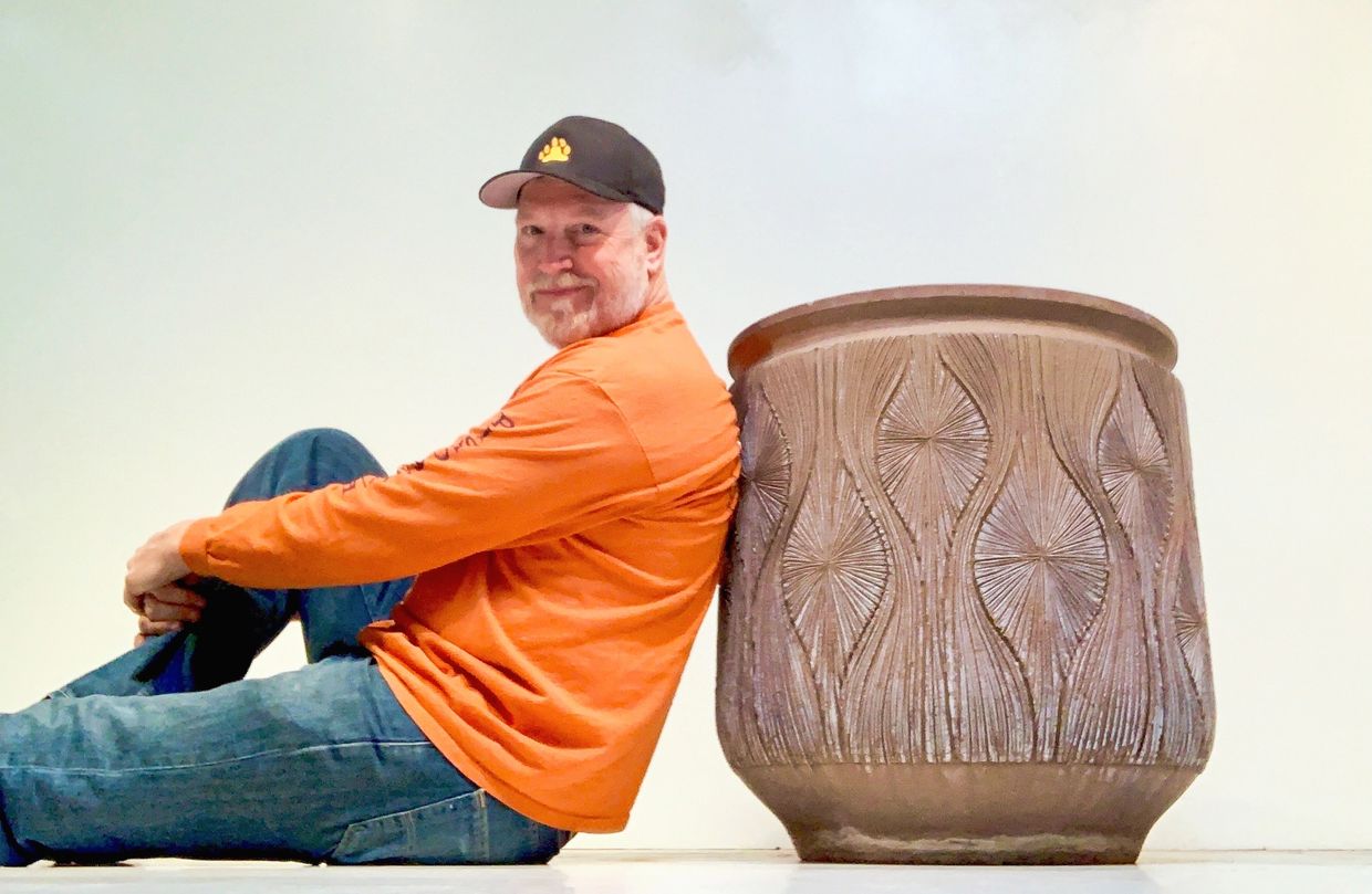 Steven Morris of Xcape Modern Vintage furniture store in Long Beach, CA poses next to a 1960s pot.