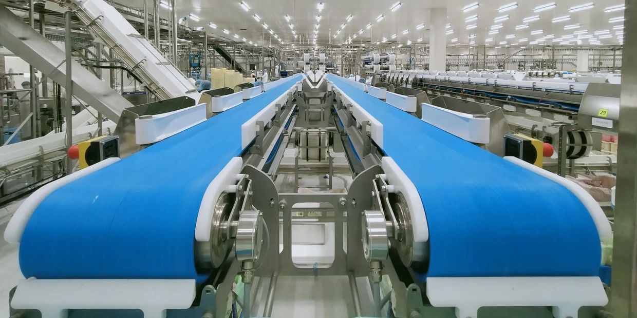 Blue conveyor belts in a large factory.