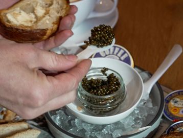 Person spreading caviar on bread.