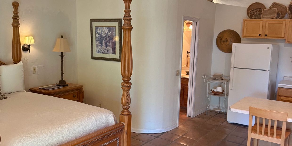 Cozy bedroom and kitchen area with wooden furniture.
