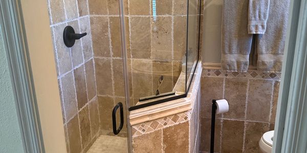 Bathroom with glass shower and tiled walls.