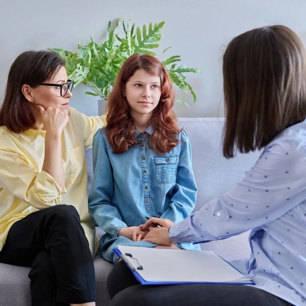 Woman comforting a young girl during a consultation.
