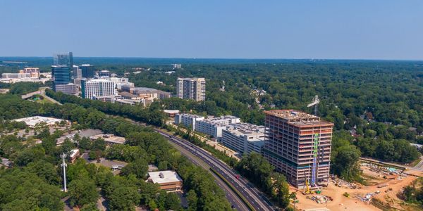 Aerial view of a cityscape with construction and greenery.