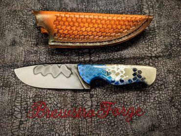 Custom knife with decorated handle and leather sheath.