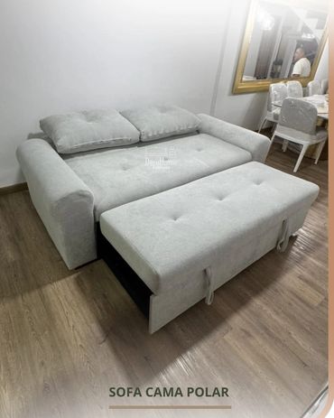 Light gray sofa bed with tufted cushions and storage ottoman in a modern room.