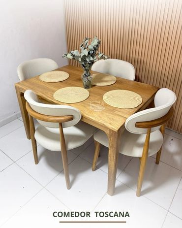 Modern wooden dining table set with four cushioned chairs and a centerpiece.