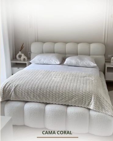 Elegant white coral bed with tufted headboard and plush bedding.