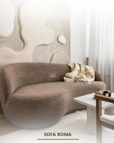 Curved brown sofa with a cozy throw in a modern living room.