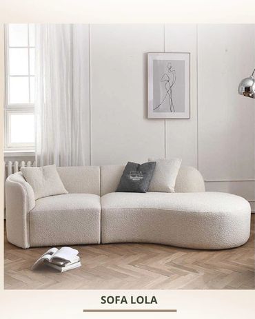 Modern white curved sofa with cushions in a minimalist living room.