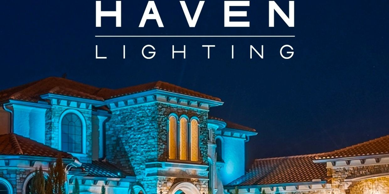 Luxurious home illuminated with elegant blue and warm yellow lighting at night.