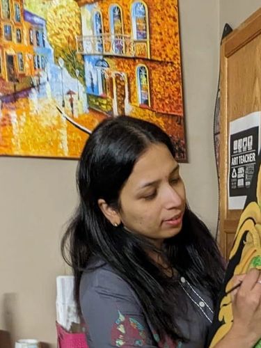 A woman painting a colorful artwork on an easel in a cozy room.