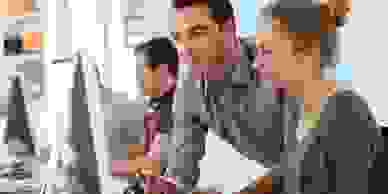 Student girl with trainer working on computer and tablet
