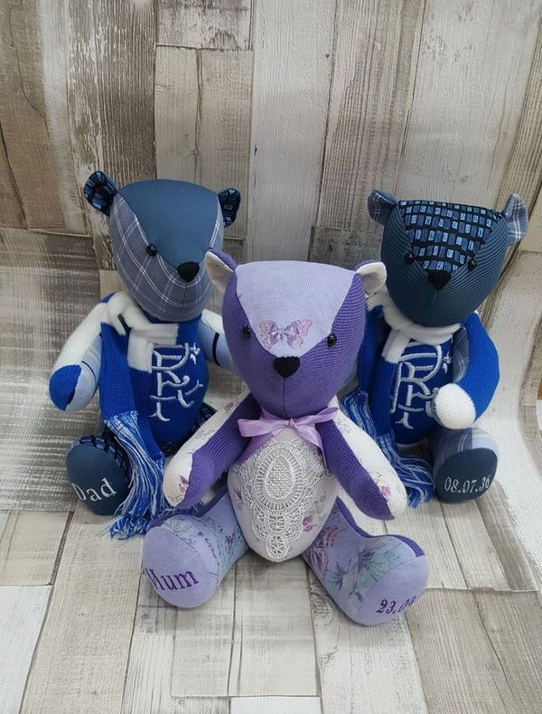 Three purple handmade memory bears on a wooden floor