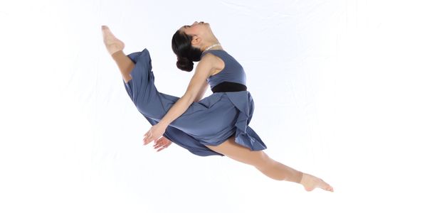 Ballerina mid-air leap in graceful dance pose.