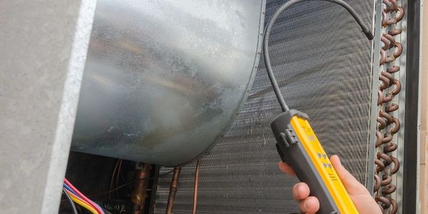 Hand-held diagnostic tool inspecting HVAC system components.