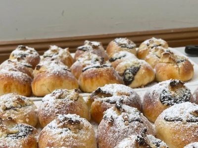 Freshly baked sweet buns topped with powdered sugar and nuts.