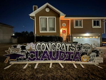 Congratulatory yard sign for Claudia at night.