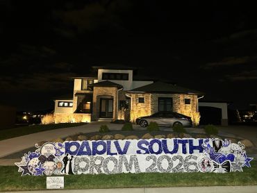 Prom sign outside a modern house at night.