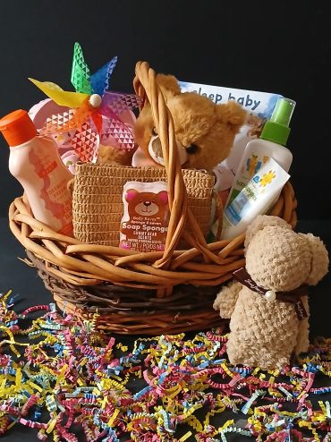Gift basket with teddy bears and baby care items.