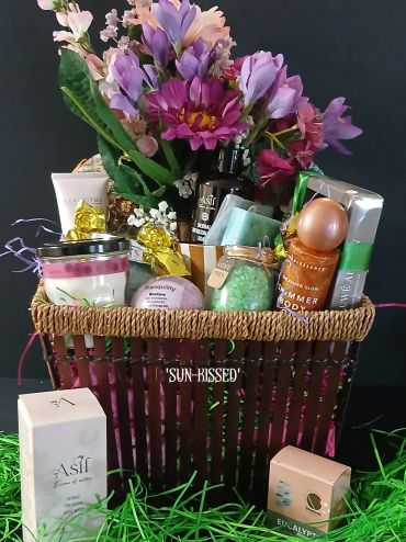 Gift basket with spa and self-care items and flowers.