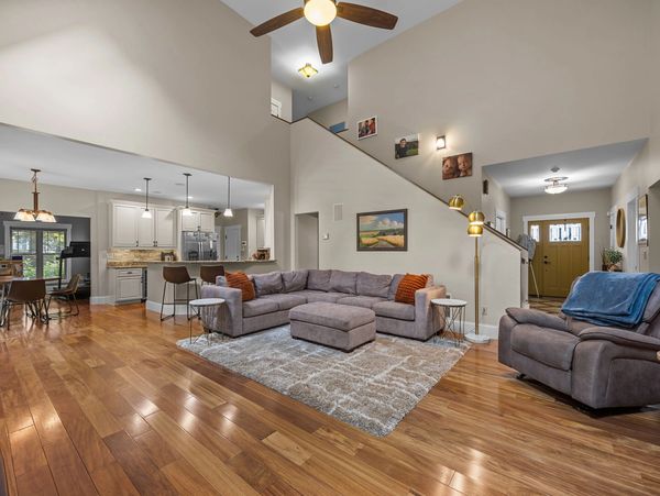 Spacious living room with modern furniture and wooden floors.