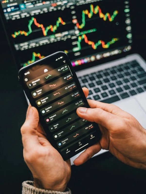 Trading software in action on a laptop and a handheld device.