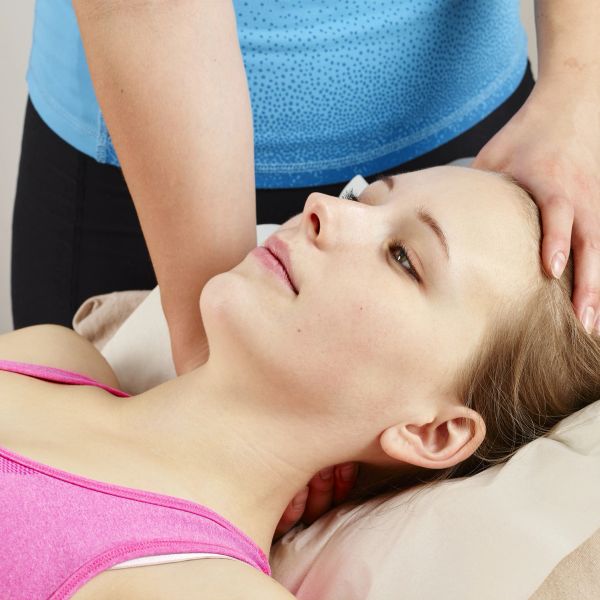 A woman receiving a head massage while lying down.