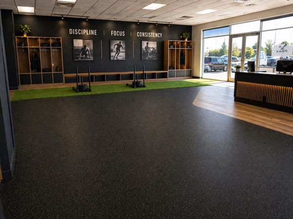 Modern gym entrance with motivational words and natural light.