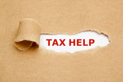 The words TAX HELP revealed under torn brown paper.